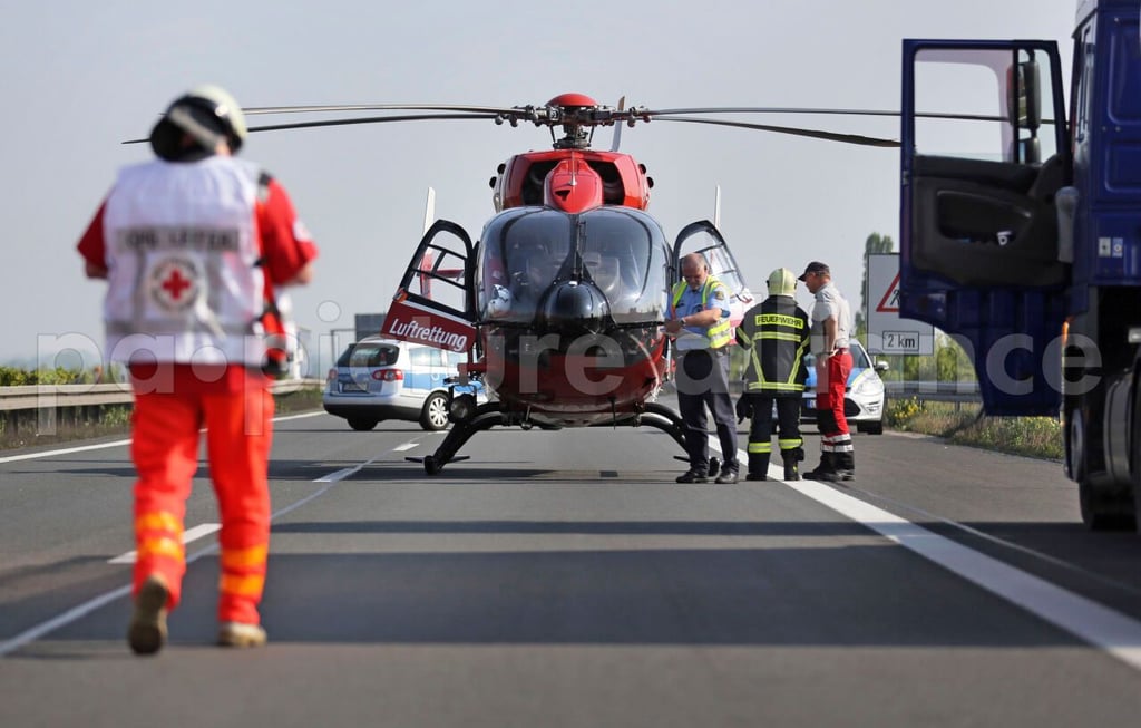 Ein Hubschrauber des Rettungsdienstes steht auf einer Autobahn.