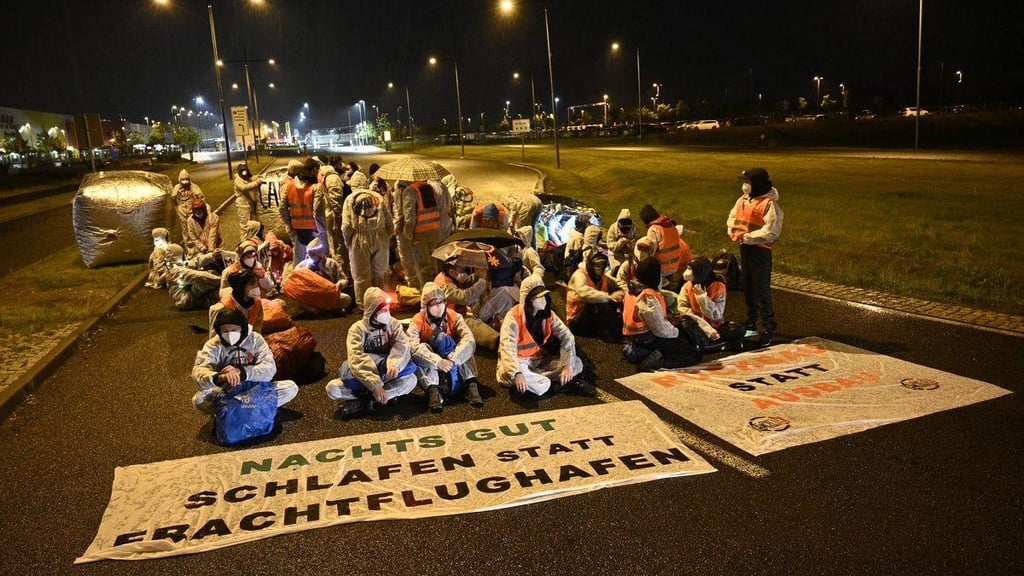 Aktivisten blockieren die Zufahrt zum DHL-Frachtzentrum 