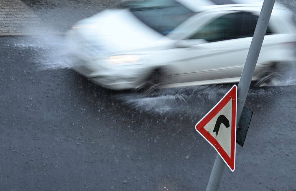 Ein Auto fährt bei Starkregen auf einer überfluteten Straße. Auch am Sonntag muss erneut mit Gewittern gerechnet werden.