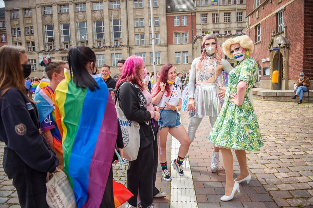 Teilnehmer:Innen stehen im Rahmen des CSD (Christopher Street Day) auf dem Rathausplatz.
