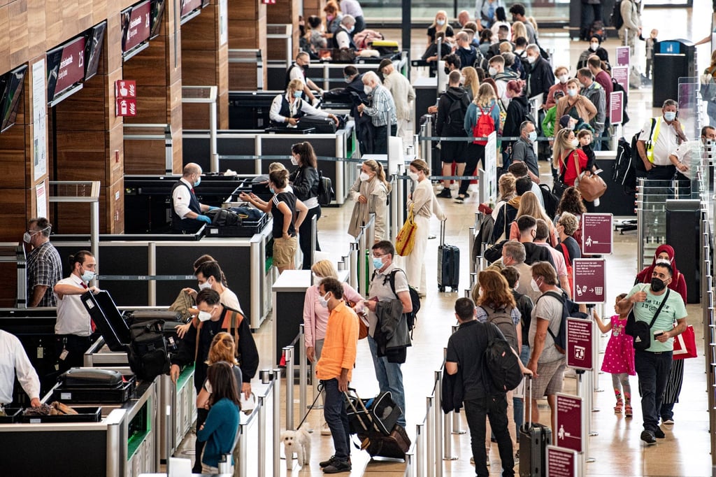 Reisende stehen am Flughafen BER am Security Check. Die Fluggastzahlen am BER haben in den vergangenen Monaten wieder deutlich zugenommen.