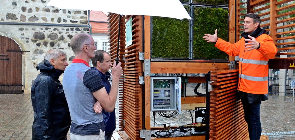 Peter Sänger, Mitbgründer von Green City Solutions erläutert Christian Eins, Projektleiter Entwicklung bei KD Elektroniksysteme, Bürgermeister Andreas Dittmann und KD-Geschäftsführer Ralf Kleinodt (v.r.) noch einmal die Funktionsweise der City-Trees.