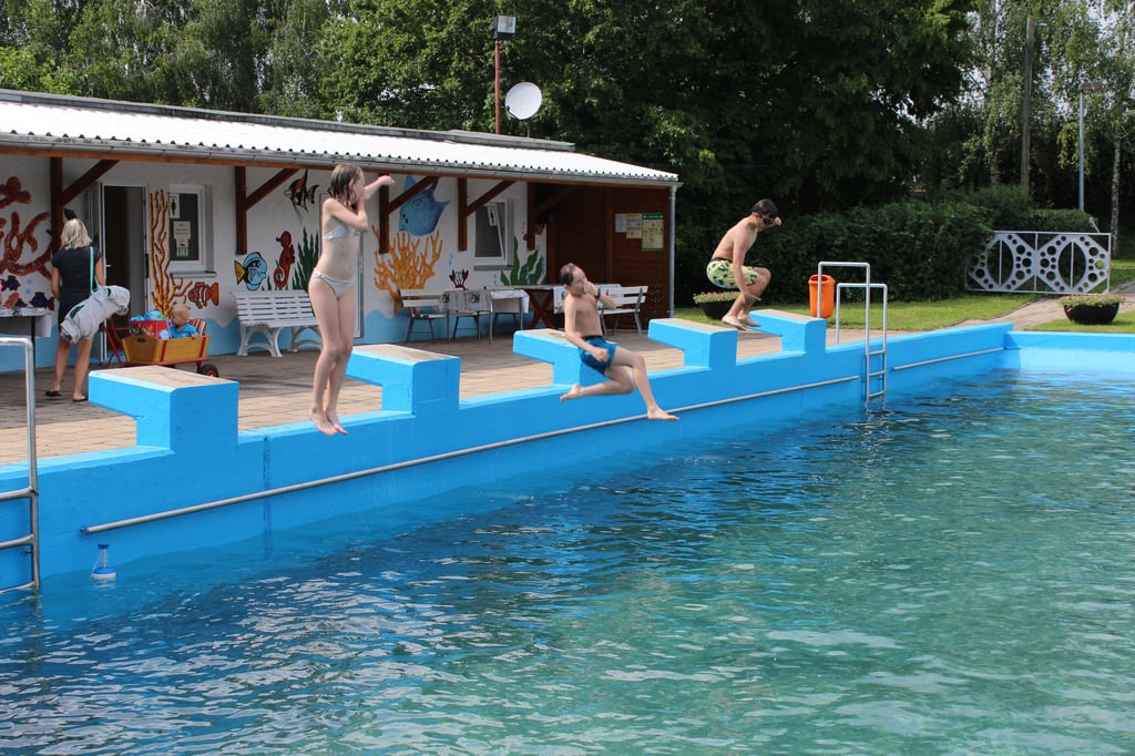 Lena, Robin und Felix (v.l.) springen von den Startblocks ins Wasser.