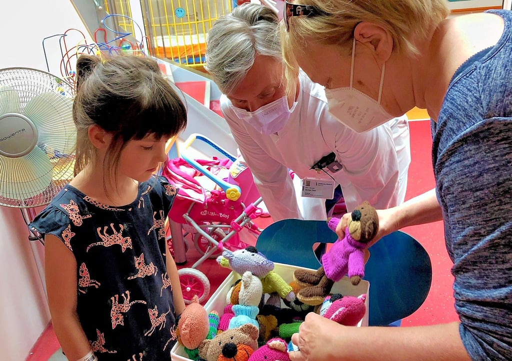 Gabriele Behrmann (r.) hat in ihrer Freizeit 30 Bären gestrickt und sie dem Städtischen Klinikum Dessau übergeben. Auf der Kinderstation freuen sich Chefarzt Dr. Fest und die sechsjährige Laura aus Roßlau.  