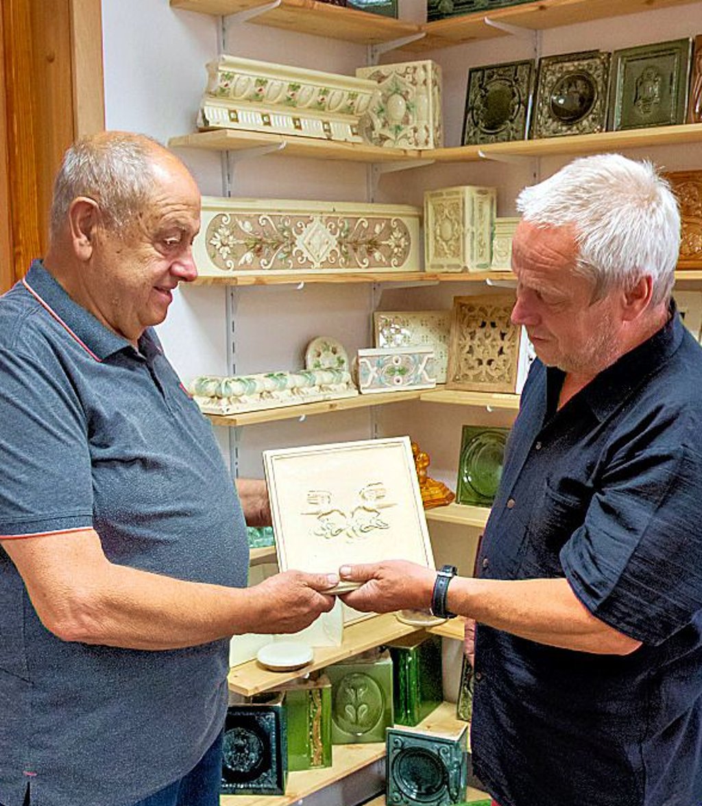 Der einstige Ofenbauer Werner Mäder (l.) schenkt Christian Wolff zur Eröffnung des neuen Museum-Domizils eine Ofenkachel aus den 1970er-Jahren.