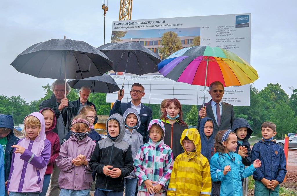 Singen unter Regenschirmen: Evangelische Grundschüler umrahmten den feierlichen Baustart mit zwei Liedern.