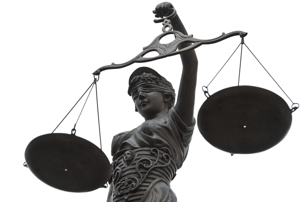 Eine Statue der Justitia mit einer Waage in ihrer Hand.