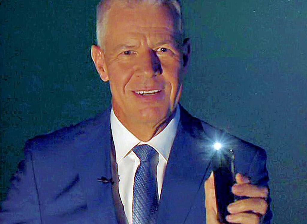 Peter Kloeppel leuchtet die Nachrichtensendung mit seiner Handy-Taschenlampe aus.