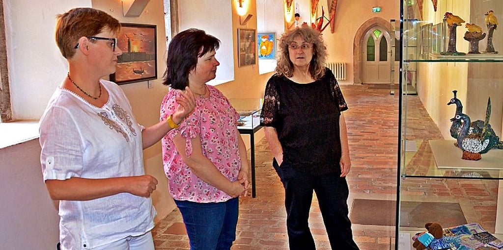 Silke Schmidt, Sabine Brauns und Museumsleiterin Agnes-Almuth Griesbach (v.l.) werfen einen Blick auf die Ausstellungsstücke der Hobbykünstler im Museum am Weinberg.