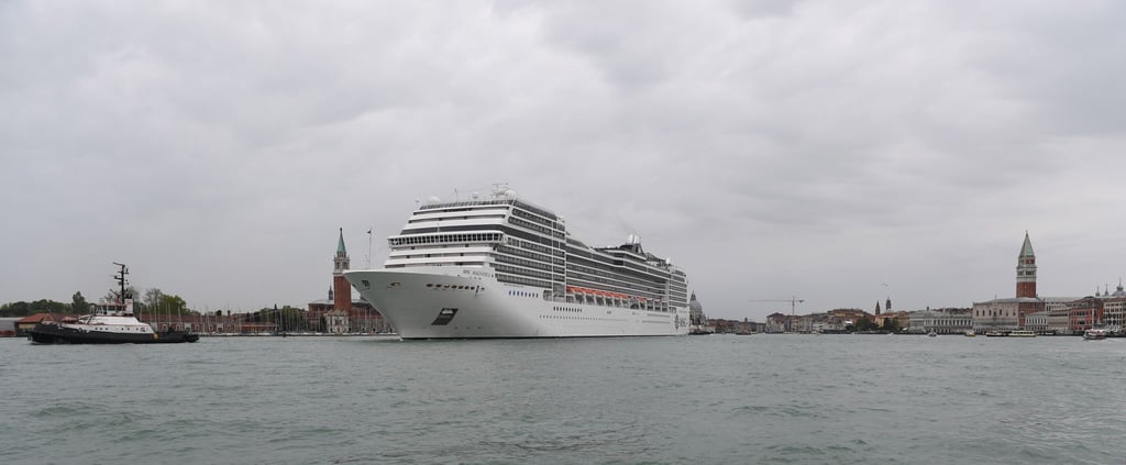 Ein Kreuzfahrtschiff fährt an der Lagunenstadt Venedig von einem Schlepper gezogen vorbei.