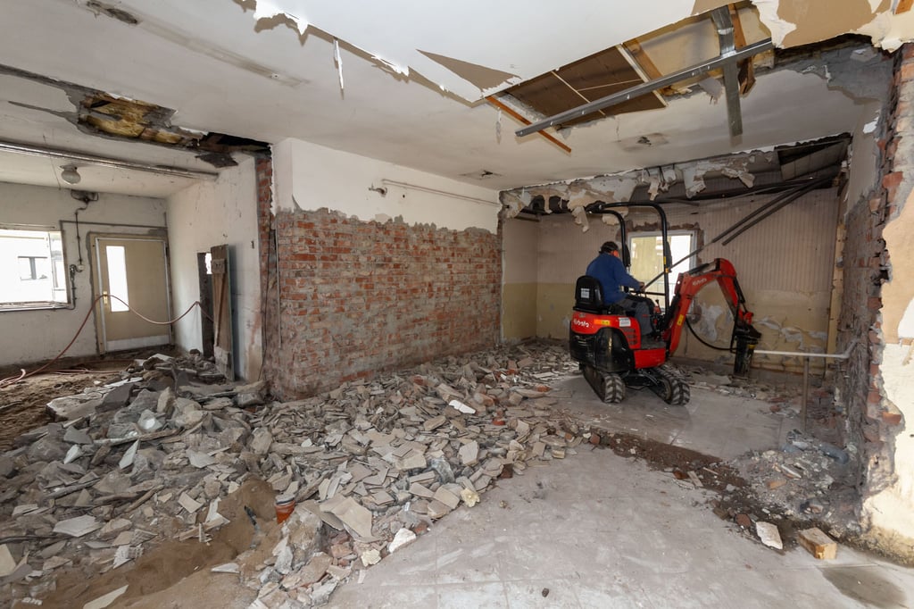Im Volkshaus Taucha stemmt Ekard Krug von der Firma Fuchs aus Taucha mit einem Bagger den Betonfußboden auf.
