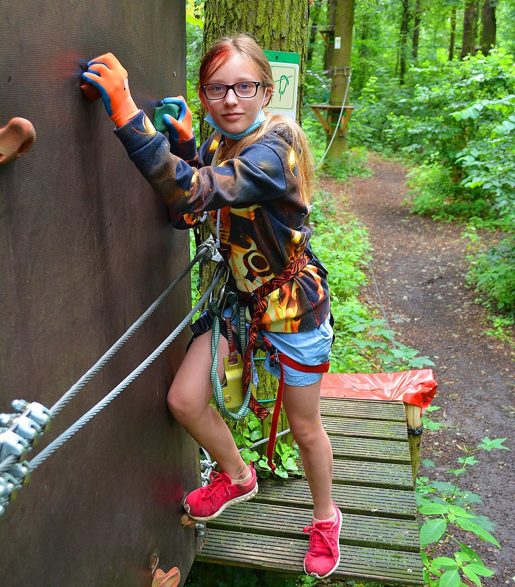 Lanie klettert an einer Wand auf die andere Seite.