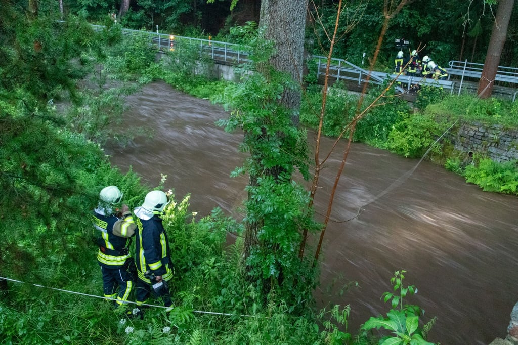 Feuerwehrleute suchen am Steinbach nach einer vermissten Person. Eine Sturzflut hatte bei einem Unwetter im sächsischen Jöhstadt (Erzgebirgskreis) einen Menschen mit sich gerissen.