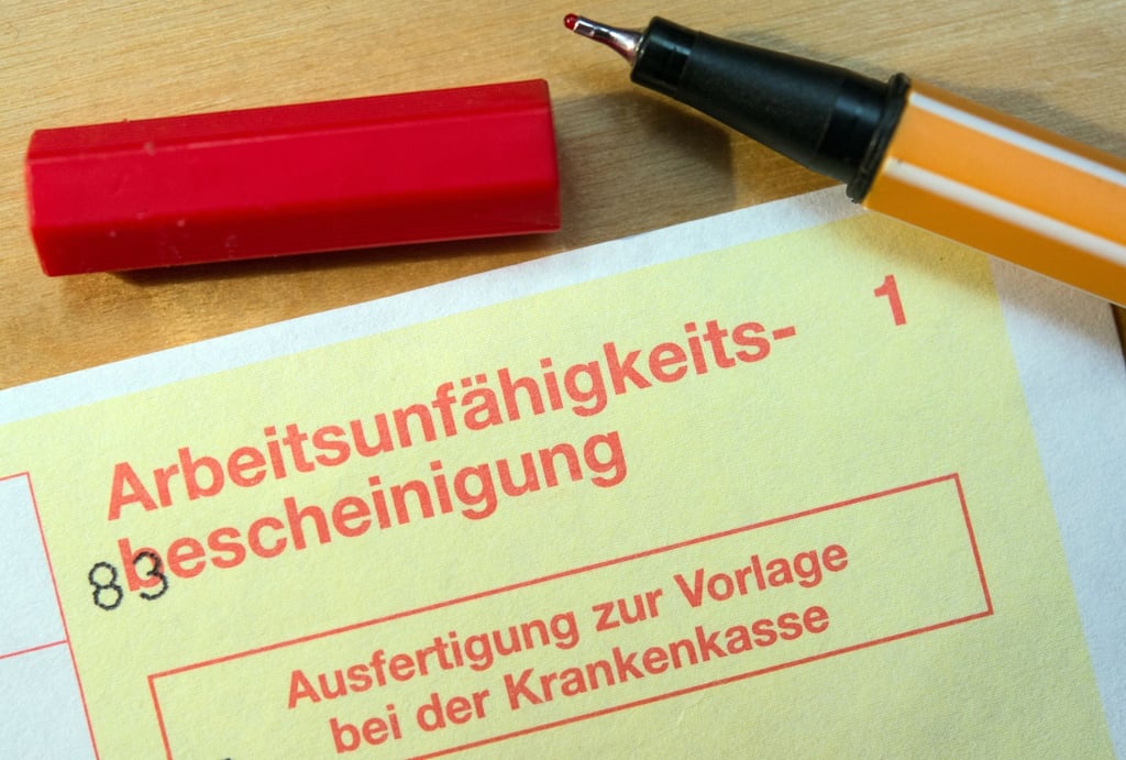 Eine Arbeitsunfähigkeitsbescheinigung liegt auf einem Tisch.