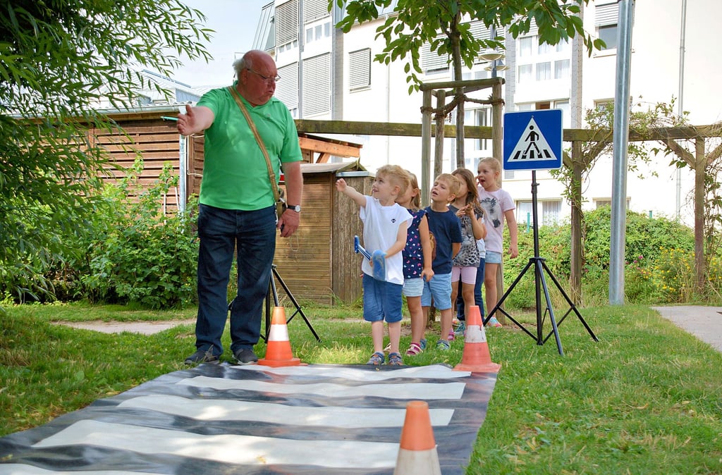 Klaus Glandien, der Vorsitzende der Kreisverkehrswacht Oschersleben, zeigt den Kindern aus der Kita ?St. Franziskus?, wie man einen Zebrastreifen überquert.