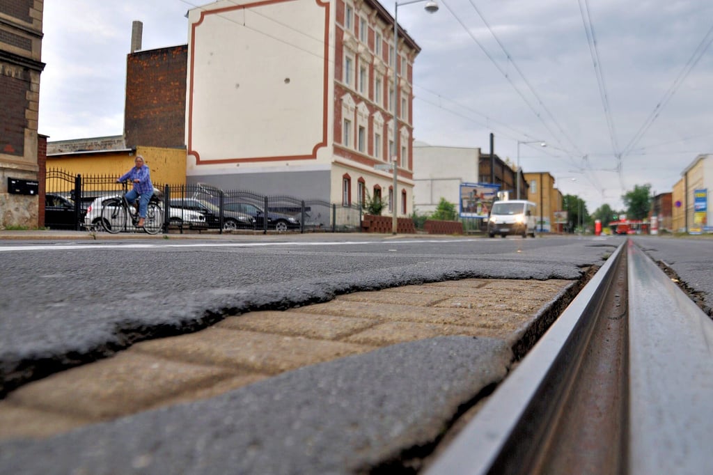 Der Straßenbelag bröckelt ähnlich wie hier im Bereich von Alt-Fermersleben an mehreren Stellen entlang der Hauptverkehrsachse durch den Südosten von Magdeburg.