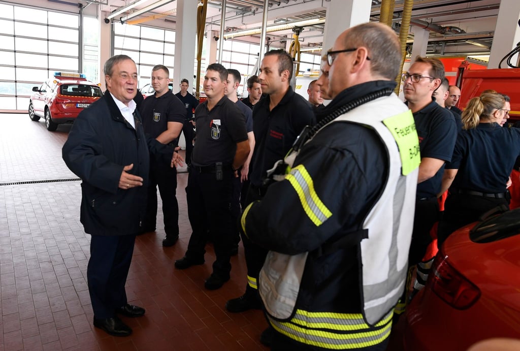 Der nordrhein-westfälische Ministerpräsident Armin Laschet (CDU, l) bedankt sich bei Hagenern Feuerwehrleuten für ihren Einsatz.
