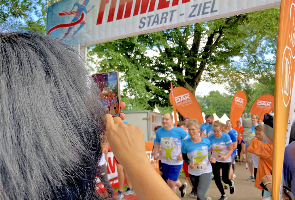 Anfeuern und dokumentieren: Anke Höfer fotografiert eins der fünf Teams ihrer Firma beim Start.