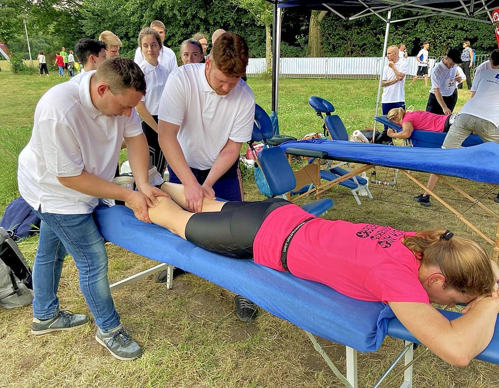 Wohltuend für Läuferinnenbeine: Manuela Büchner genießt eine Sportlermassage von Jakob Lange (links) und Sönke Windischmann.
