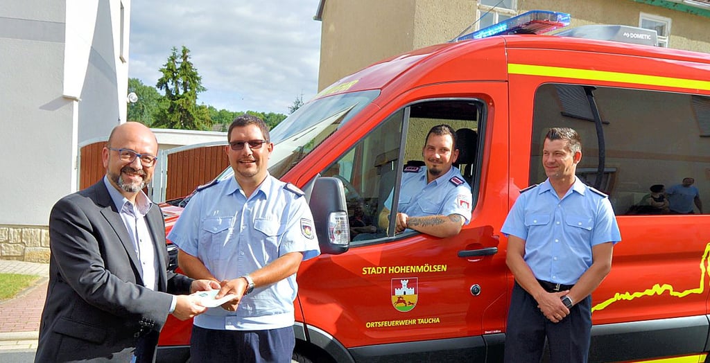 Bürgermeister Andy Haugk (l.) übergibt die Fahrzeugpapiere für den neuen Mannschaftstransportwagen an Ortswehrleiter Lars Schmoranzer.