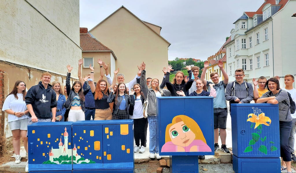 Kunstlehrerin Christina Simon (2.v.r.) und die Elftklässler des Goethegymnasiums stellten OB Robby Risch (hintere Reihe mit weißem Hemd) und Stadtwerke-Chef Lars Meinhardt (hinten, verdeckt) die Ergebnisse ihrer Arbeiten vor. In der Fischgasse sind Motive aus Disneys Film ?Rapunzel? zu sehen.
