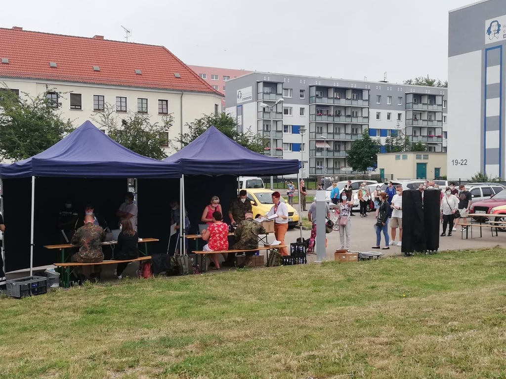 In Magdeburg-Neustadt stehen Menschen Schlange am Impfzelt.