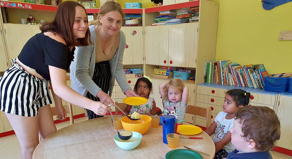 Ronja Huthmann und Nele Kuska füllen den Kindern im „Zwergenland“ das Mittagessen auf. An dem Tag gab es Senfeier.