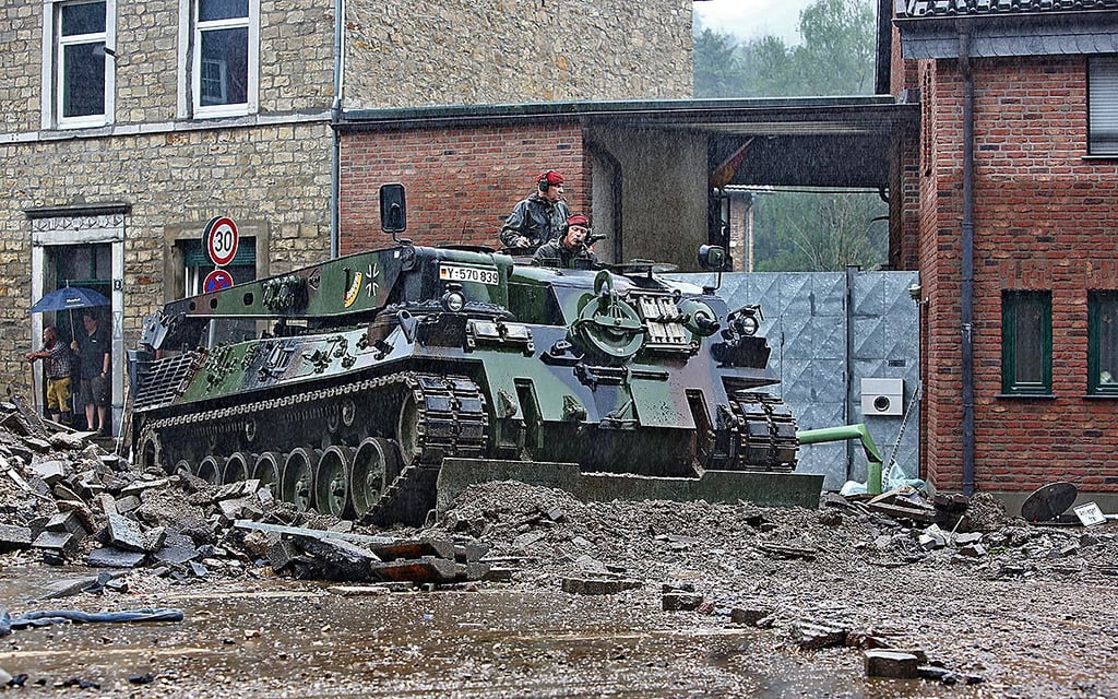 Ein Einsatzfahrzeug der Bundeswehr räumt in Aachen Geröll von der Straße.