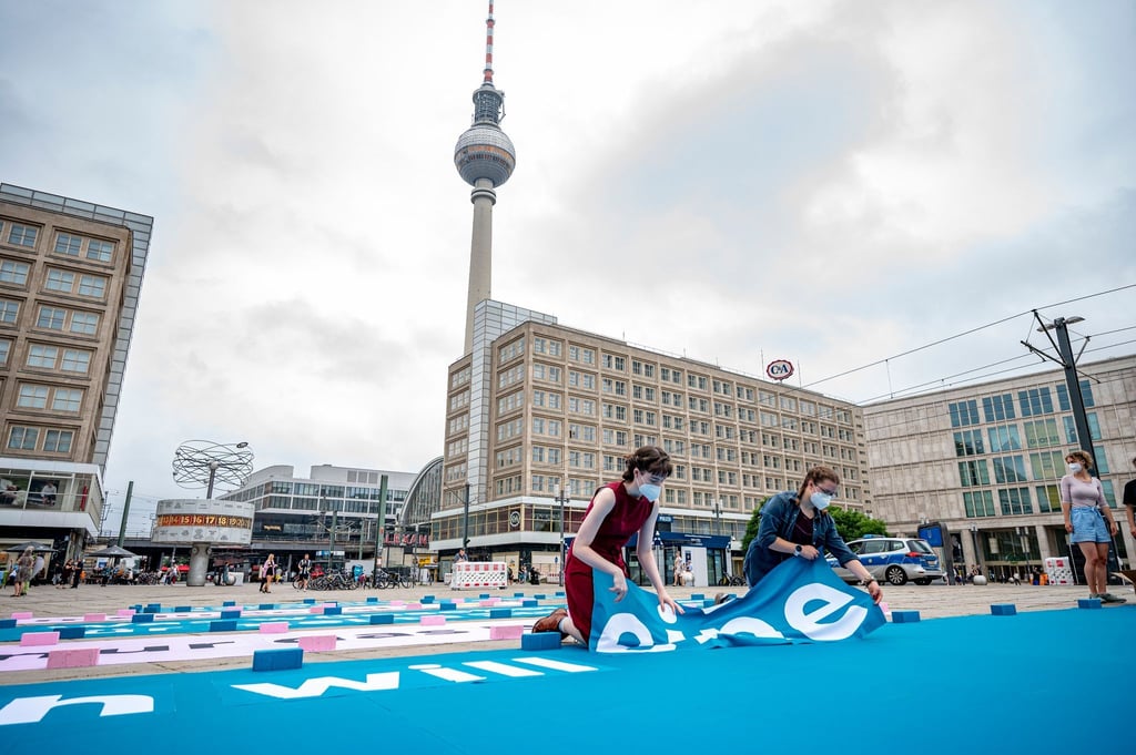 Greenpeace-Aktivisten legen auf dem Alexanderplatz einen 25 Meter großen Chatverlauf als Bodenbanner.
