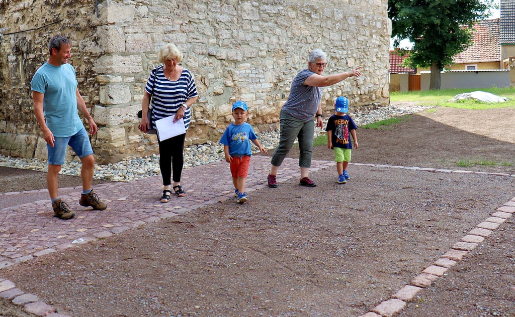 Landschaftsgärtner Dirk Horenburg, Ortsbürgermeisterin Waltraud Beck und Anwohnerin Brigitte Meier mit den Nachbarskindern Björn und Arne (von links) begutachten die neuen Parkplätze an der Martinikirche von Schlanstedt.