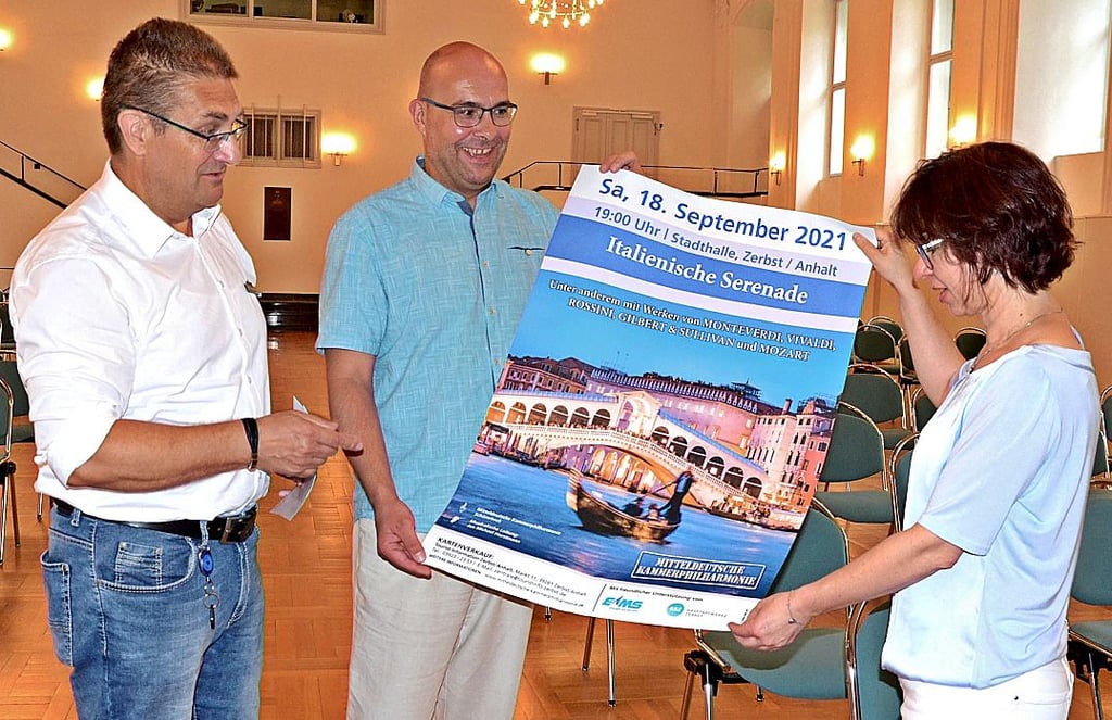 Frank Sieweck, Sprecher der Erdgas Mittelsachsen, Orchester-Sprecher Mike Schmidt der Mitteldeutschen Kammerphilharmonie Schönebeck und Schlossverein Vorstandsmitglied Jana Reifarth (v.l.) philosophieren über das gekungene Plakat.