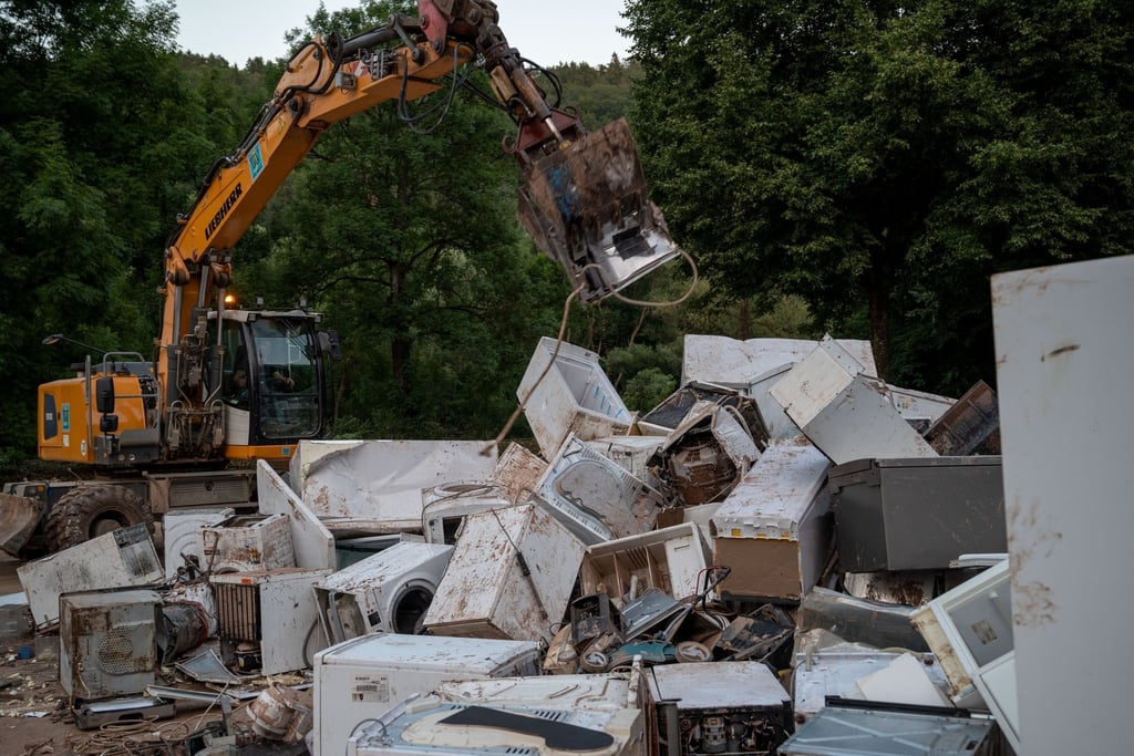 Ein Bagger entsorgt in Kordel (Rheinland-Pfalz) Elektrogeräte, die durch das Hochwasser beschädigt wurden.