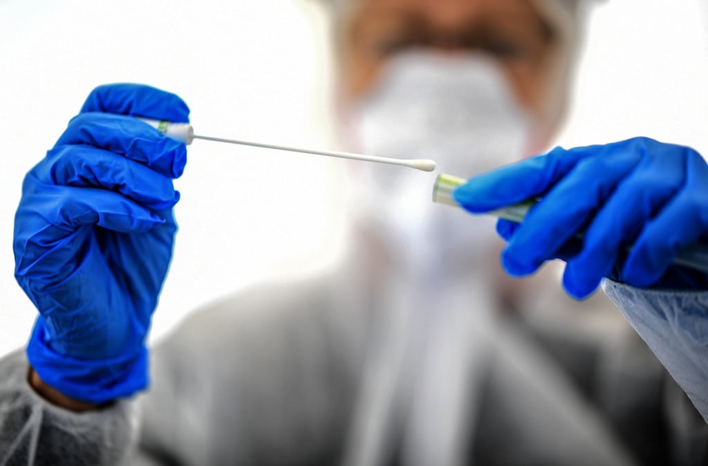 Ein Abstrichstäbchen wird in einer ambulanten Corona-Test-Einrichtung für die Analyse vorbereitet.