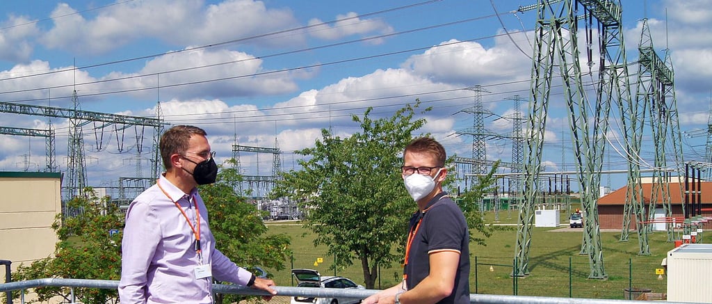 Die 50-Hertz-Mitarbeiter Axel Happe und Eric Michel stehen auf der Plattform des Infopunktes im Umspannwerk. Von dort aus können später die Bauarbeiten beobachtet werden.