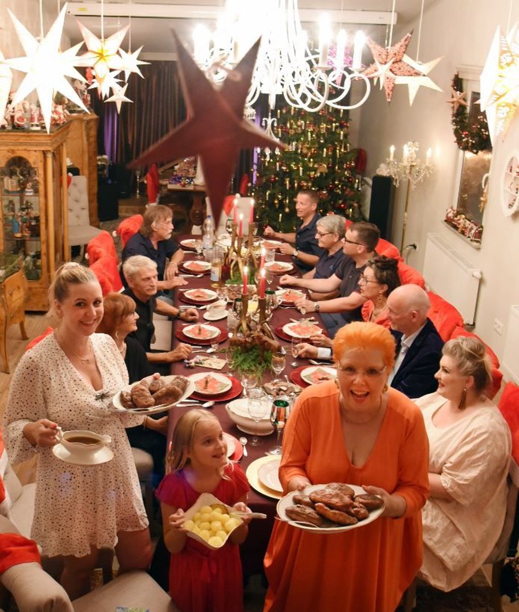Martina Sawatzke steht mit ihrer achtjährigen Enkeltochter Alisia und ihrer Tochter Eva (r-l) mit dem Festessen im geschmückten Weihnachtszimmer. Mitten im Hochsommer holen der 70-jährige Dietmar Sawatzke und seine gleichaltrige Frau Martina das im Dezember wegen der Corona-Pandemie kleiner ausgefallene Weihnachtsessen in großer Runde mit Freunden und Familie nach.