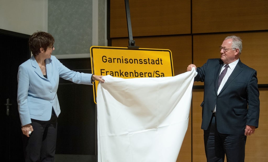 Bundesverteidigungsministerin Kramp-Karrenbauer und Frankenbergs Bürgermeister Firmenich enthüllen ein Ortseingangsschild der Stadt Frankenberg mit dem Namenszusatzes „Garnisonsstadt“.