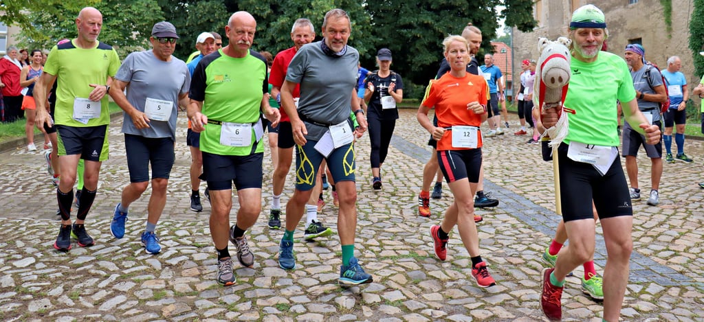 Auftakt zum 18. Huy-Burgen-Lauf. Gestartet wurde in Gruppen zu je 20 Läufern. Hier die erste Abteilung mit den sechs Aktiven, die immer dabei waren. Ganz vorn Detlef Ilse aus Braunschweig, der zum 16. Mal beim Laufereignis dabei ist. Er ist nie alleine unterwegs, sondern hat immer seinen treuen Begleiter, ein Steckenpferd, dabei.