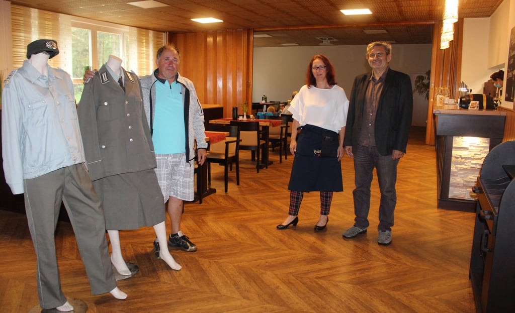 Auf Zeitreise kann man in der am Donnerstag eröffneten neuen Kantine bei den Fläminger Entenspezialitäten gehen. Der Reudener Ortsbürgermeister Elard Schmidt (l). brachte Michael Bügener und Sandra Schmidt als Geschenk zwei Uniformen aus NVA-Zeiten für die Gaststätte mit.