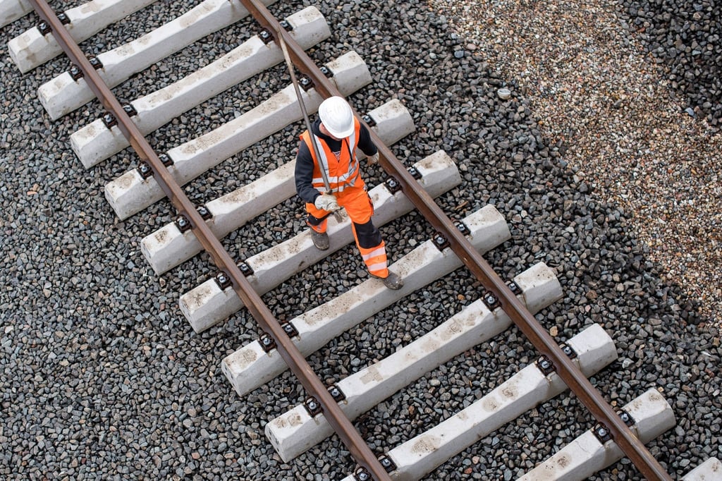 Ein Arbeiter geht über eine noch nicht fertige Gleisanlage der Bahn.