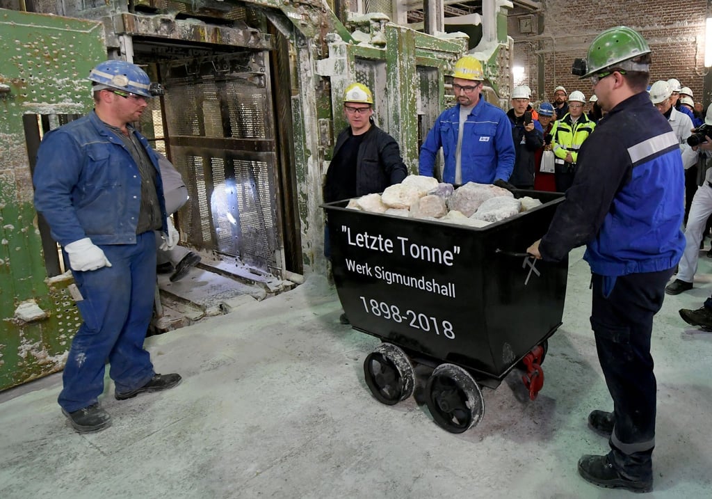Bergleute neben dem letzten Förderwagen mit Salz, der aus dem Kali-Bergwerk Sigmundshall gefördert wurde.