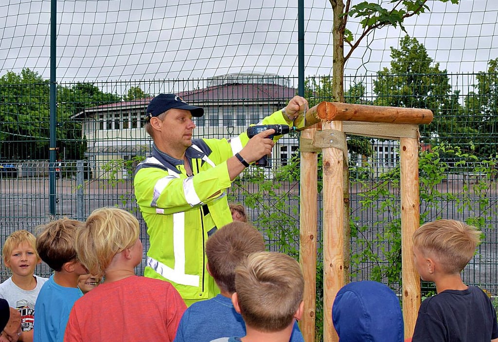 Als der Regen etwas nachließ, schraubte Hausmeister Stefan Böttcher die von Bäcker Brademann gesponserten Namensschilder an.
