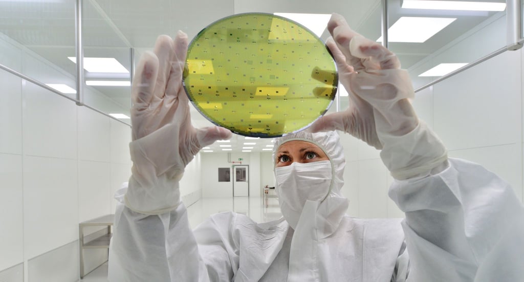 In einem Reinraum wird ein Siliziumwafer für die Halbleiterherstellung geprüft.