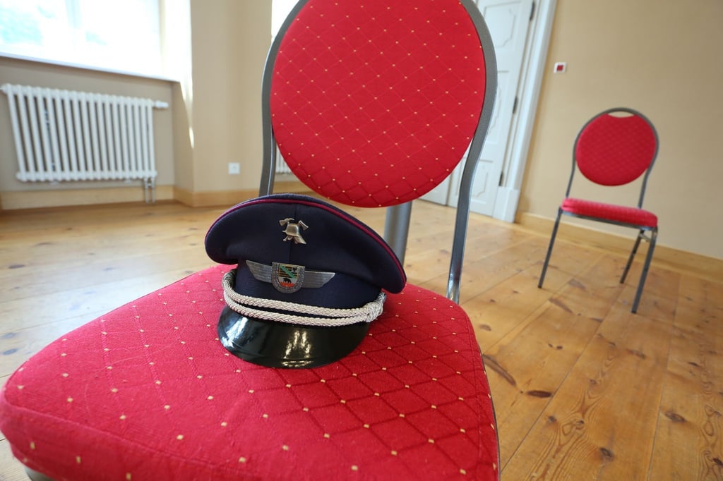 Eine Dienstmütze der Feuerwehr liegt auf einem Stuhl.
