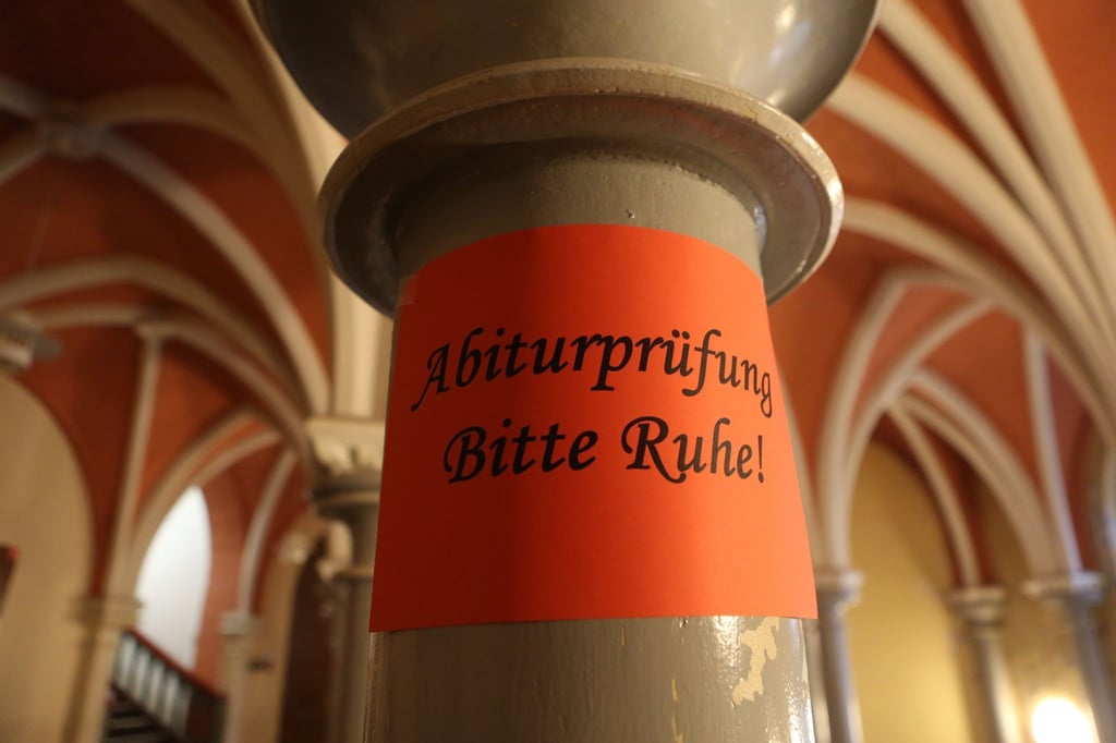 Ein selbst gefertigtes Hinweisschild informiert über den beginn der schriftlichen Abiturprüfung.