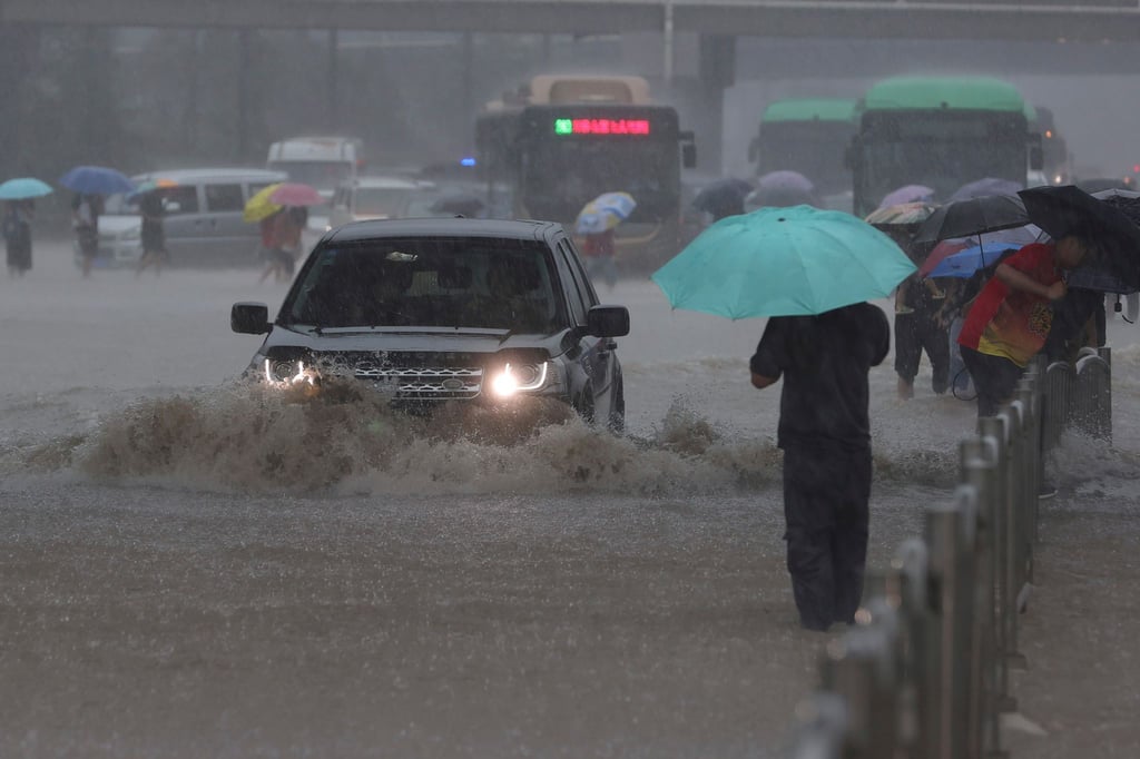 Ein Auto fährt in der zentralchinesischen Provinz Henan über eine überflutete Straße.