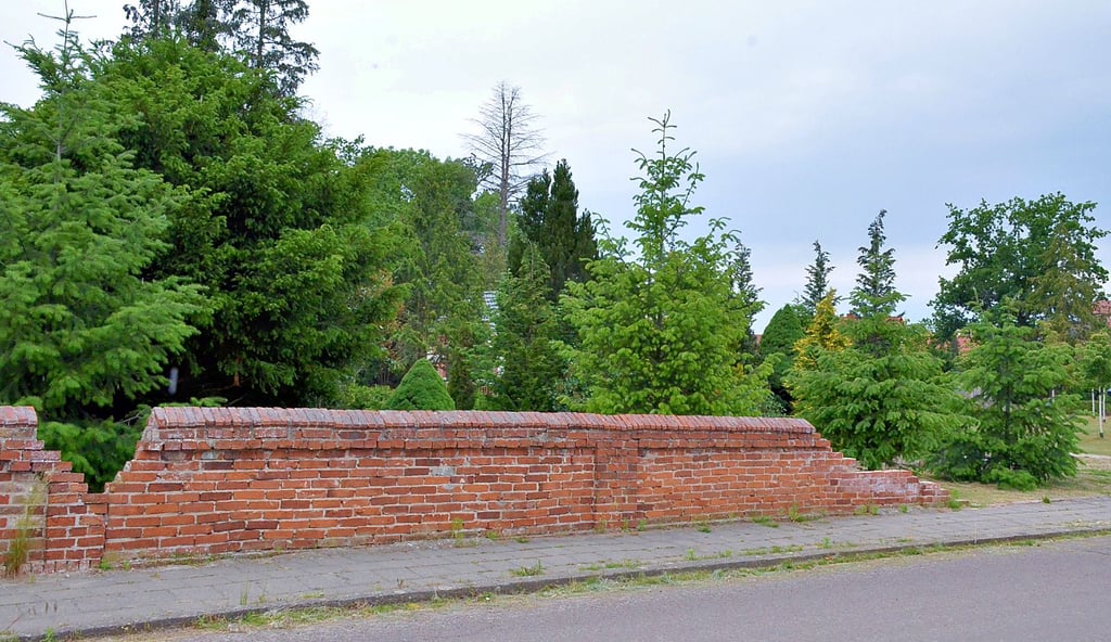 Die Mauer um den Sandauer Friedhof war schon so marode, dass große Abschnitte zwecks Gefahrenabwehr abgetragen wurden. Nun wird statt der Mauer ein Zaun errichtet.