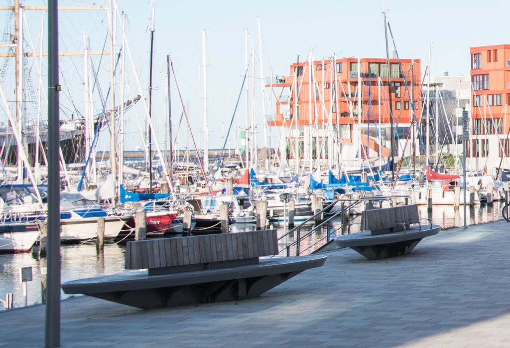 Sitzbänke stehen an der Hafenpromenade.