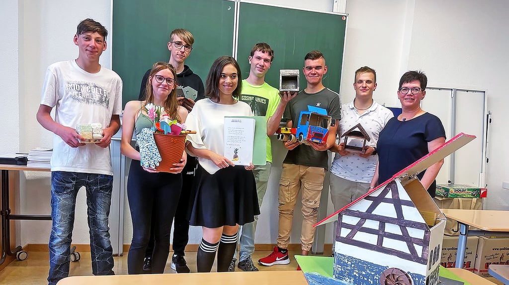 Die Schüler der Klasse des ?Produktiven Lernens? (hier mit Lehrerin Beatrice Mollnau) halten selbst hergestellte Modelle in den Händen, mit denen sie die Inhalte verschiedener Praktika veranschaulichen. Stanley aus Zeitz (3.v.r) hat ein Lkw-Modell gebastelt. Vorn im Bild: die Unstrut-Mühle in Zeddenbach.