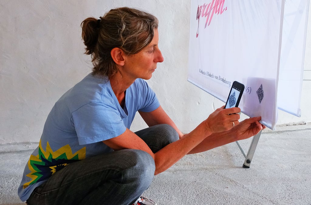 Petra Reichenbach versucht mit ihrem Smartphone den QR-Code zu scannen. Nach anfänglichen Problemen läuft jetzt alles reibungslos.