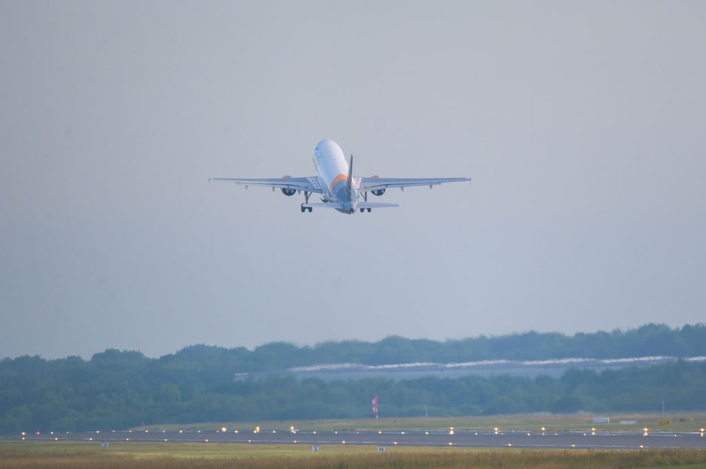 Ein Flugzeug hebt am frühen Morgen von der Startbahn ab.